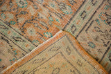 Distressed vintage Oushak showing worn pile texture and reverse foundation in pale apricot, mint, ivory.