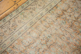 Distressed Oushak carpet texture with even wear across knot heads, pale apricot, and mint.