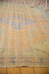 Distressed Oushak rug's even pile wear, revealing faint foundation with secured fringe.