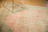 Distressed vintage Oushak rug with soft pink, seafoam, and ivory Rococo patterns.