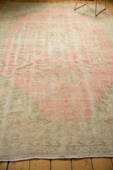 Distressed pink and seafoam green pile, showing wear across knot heads and foundation.