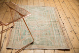 Distressed Oushak rug showing worn pile, exposed foundation, and pale plant vinery.