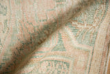 Distressed vintage Turkish Oushak rug showing worn pile texture in pale blush and seafoam green.