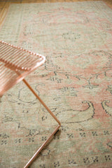 Distressed vintage Oushak rug pile with faded blush, seafoam, and charcoal vinery.