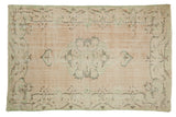 Distressed Oushak carpet with soft beige field, faded seafoam green Rococo medallion and border.