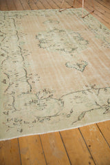Distressed vintage Oushak rug corner, showing wear to knot heads and original selvage fringe.