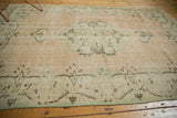 Detail of distressed Oushak carpet border, showing seafoam green vinery and faint foundation.