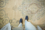 Distressed Turkish Oushak carpet's worn ivory ground with pale blue and bronze paneled leaves.