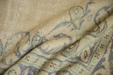 Distressed vintage Oushak rug texture in muted beige, pale blue, and seafoam green.