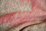 Textured distressed Oushak rug pile with blended pale raspberry and beige tones.