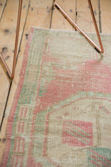Distressed pile texture of the vintage Oushak rug with soft pink, seafoam, and ivory.
