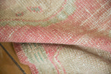 Distressed vintage Oushak rug pile texture with soft pink, ivory, and seafoam green tones.