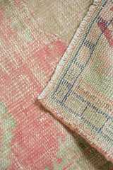 Distressed pink Oushak pile and hand-knotted foundation with colorful warp threads.