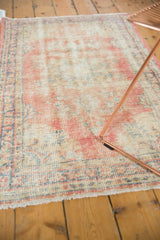 Distressed Oushak rug texture revealing wear to knot heads in blush, sky blue, and ivory.