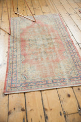 Distressed vintage Oushak rug runner showcasing its aged texture, dusty blush, and sky blue border.