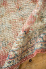 Distressed vintage Oushak runner pile showing worn knot heads, in dusty blush and sky blue.