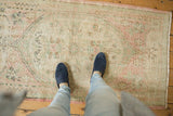 Distressed Oushak runner with mostly even wear, featuring muted blush and seafoam green.