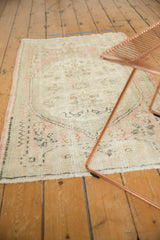 Distressed Oushak runner, worn pile, seafoam green, dusty blush floral motifs, intact selvage.