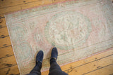 Distressed vintage Turkish Oushak rug detail, showing soft pink, blush, and seafoam green pile with even wear.