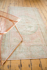 Distressed Oushak rug pile texture with blush, seafoam green tones and worn finish.