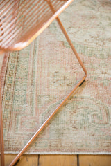 Distressed Oushak rug with faded pink, seafoam, ivory tones, mostly even wear, and intact selvages.
