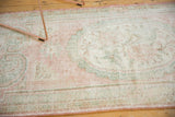 Distressed vintage Oushak rug texture, soft pink, seafoam green, and ivory worn patterns.