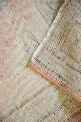 Hand-knotted reverse and distressed, worn pile texture of a vintage Oushak rug in ivory, pink hues.