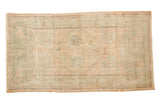Vintage Distressed Oushak rug runner featuring a pale rose medallion and soft green florals.