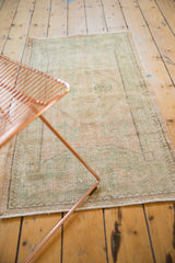 Distressed Oushak runner texture highlighting faded seafoam green, pale rose, and visible wear.