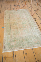 Distressed vintage Oushak runner corner with mostly even wear, pale rose and seafoam green.