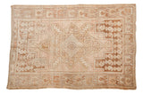 Distressed Oushak rug, central diamond medallion, primitive leaf, boteh motifs, faded sand and rose.