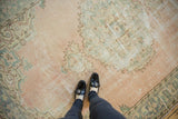 Distressed vintage Oushak carpet showing pale rose, seafoam green, and wear to knot heads.