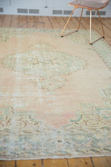 Close detail of the soft fringe and worn pale green-beige border of a distressed Oushak rug.