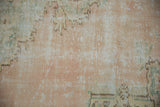 Distressed Oushak carpet close-up, mostly even wear with foundation, pale rose, green hues.