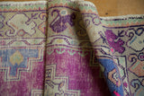 Distressed Oushak runner pile texture reveals bright purple and faded denim blue.