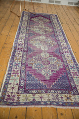Distressed violet purple and pale navy blue field with sand border and fringe.