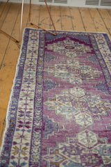 Distressed Oushak runner detail: geometric border, stepped medallion, violet and blue abrash.