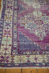 Distressed Oushak rug runner detail: vibrant violet and blue abrashes on floral border and fringe.