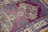 Brilliant violet Oushak rug with distressed texture, pale navy stepped motifs and visible abrashes.