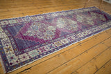 Vintage Oushak runner corner with distressed violet field and stepped blue medallion motifs.