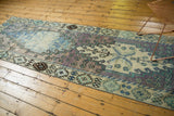 Faded ivory, pale lavender, and mint geometric border on a distressed Oushak rug runner.