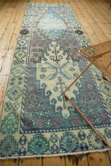 Distressed vintage Oushak rug end showing even wear, pale fringe, lavender, and mint patterns.