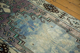 Distressed Oushak runner pile's even wear, faint foundation, pale lavender, and blue.