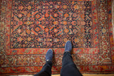 Allover Herati motif in navy, tomato red, tangerine on antique Malayer rug. Geometric vine and Samovar border, even wear.