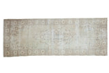 Vintage Distressed Sparta rug runner in faded ivory and beige, scalloped medallion.