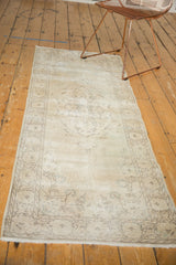 Faded patterns and visible knot heads on distressed Sparta rug end, with fringe.