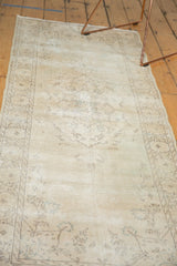Distressed vintage Sparta runner, revealing faded ivory and soft beige patterns and wear.