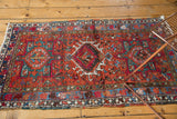 Detail of the vintage Karaja rug's geometric medallion with mallard green and sky blue hook designs.