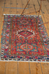 Vintage Karaja rug showing geometric hook patterns in brick red and mallard green.