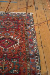Polychromatic side selvage and geometric floral patterns of a vintage Karaja rug in brick red and sky blue.